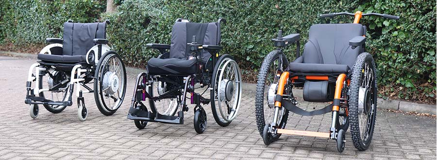 Three modern manual and power-add-on wheelchairs lined up outdoors