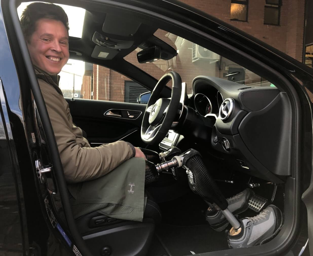 Tom Neathway sitting in the driver's seat of his adapted Mercedes-AMG A45
