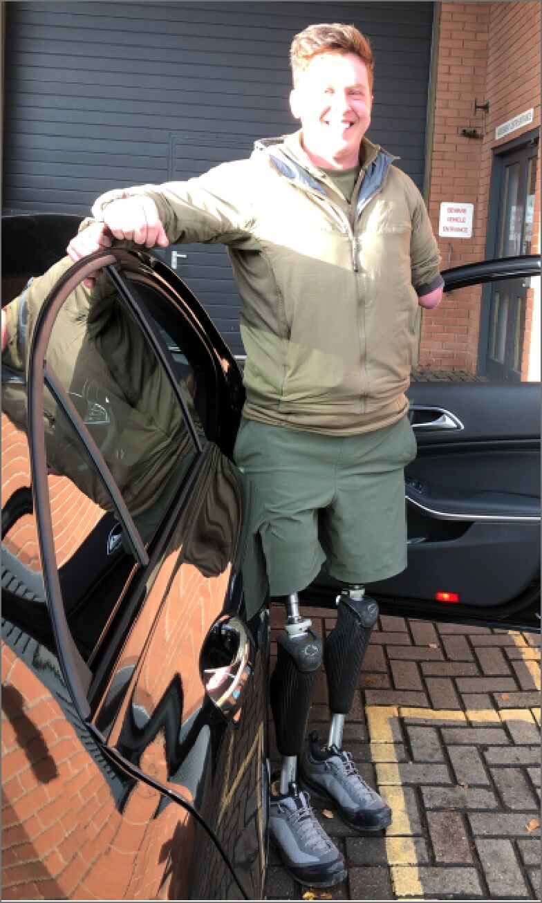 Tom Neathway standing beside the open door of his Mercedes-AMG A45 outside the workshop