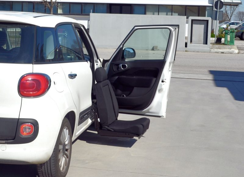 Elap E-Motion S swivel seat extended outside the open door of a white car