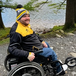 Gavin Wilson using his SD Motion Drive wheelchair with a freewheel beside a lake