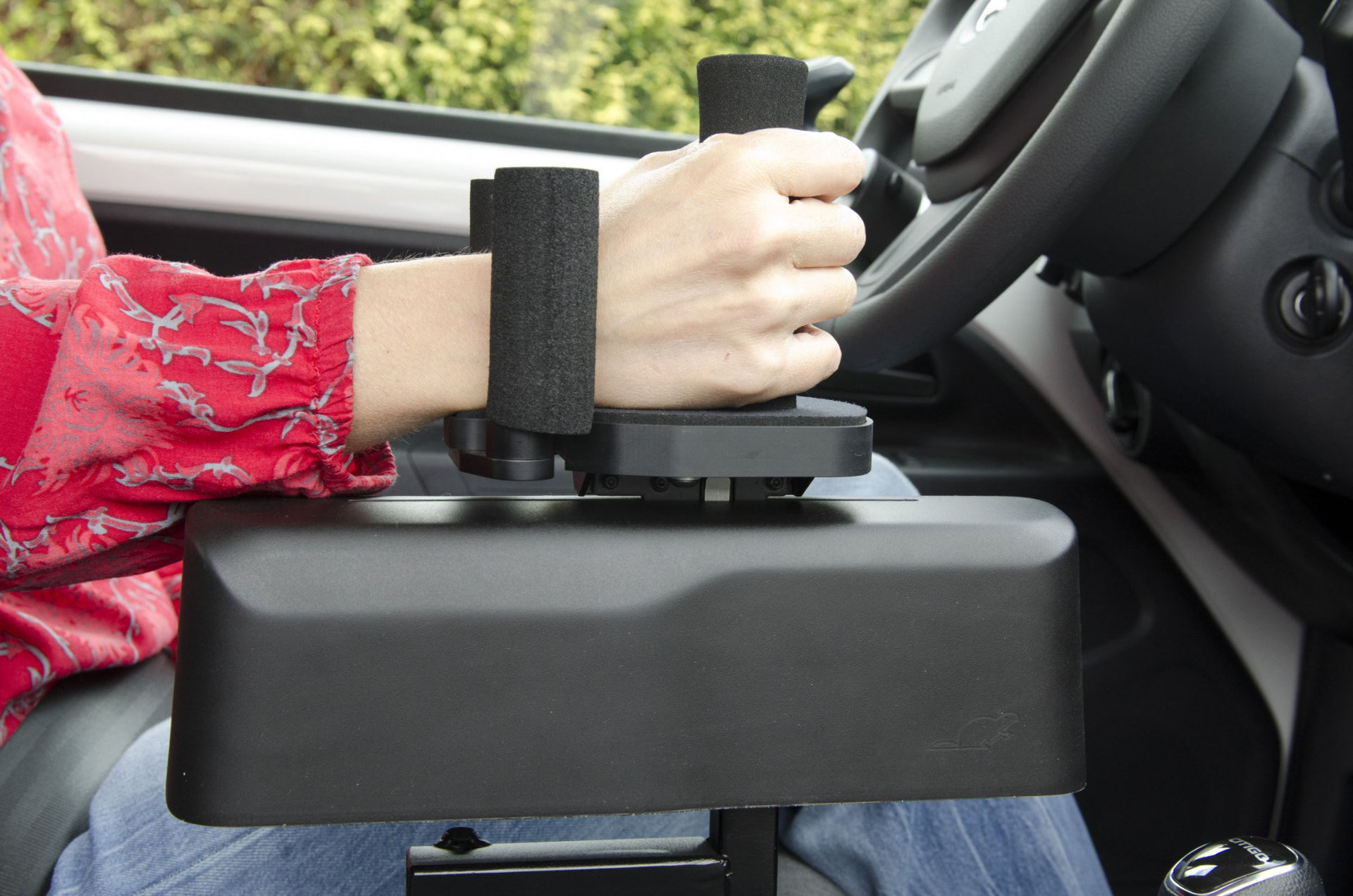 Driver operating a Bever SmartBrake hand control fitted beside the steering wheel