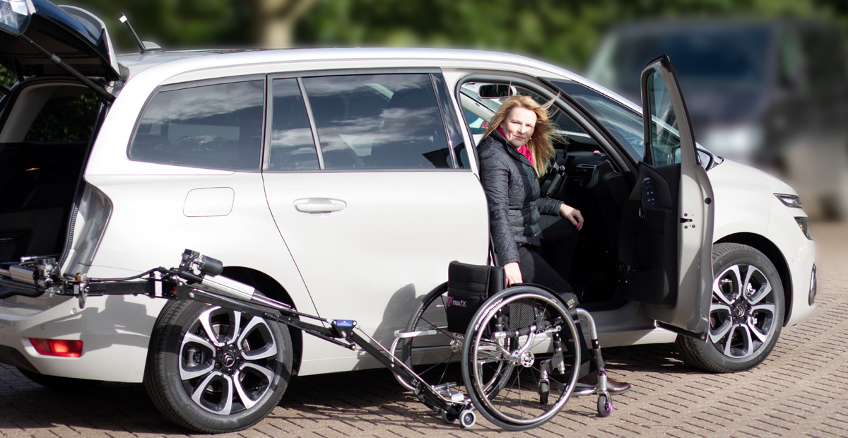 Abi Loader robotic arm delivering a manual wheelchair from the boot of an estate car